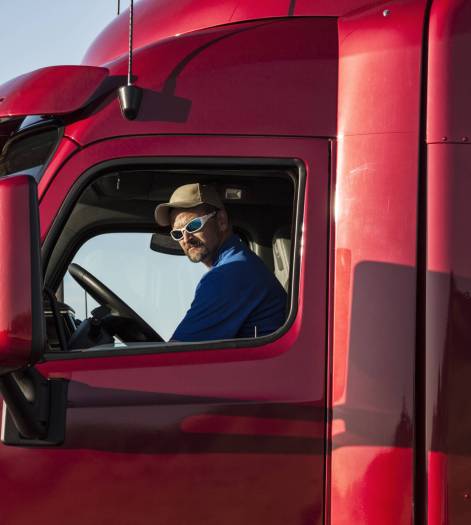Truck driver, man in a red lorry cab.